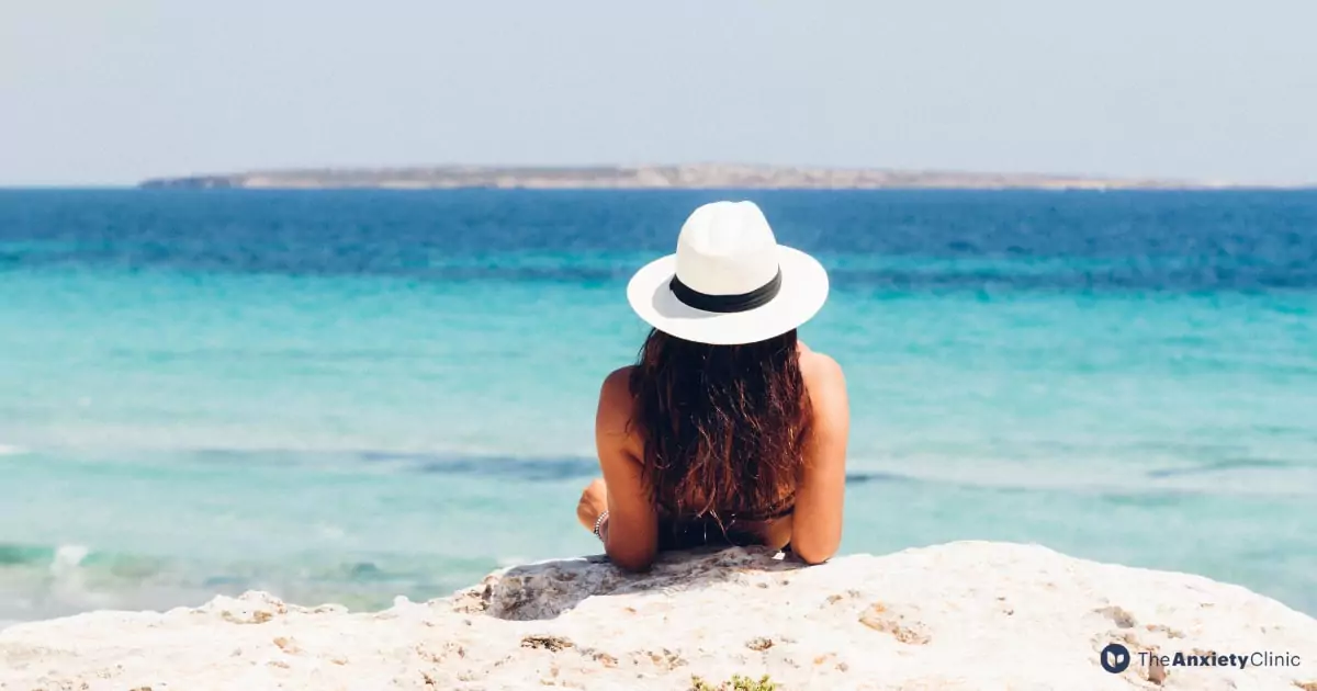 A person sitting on the sand promoting emotional well-being.